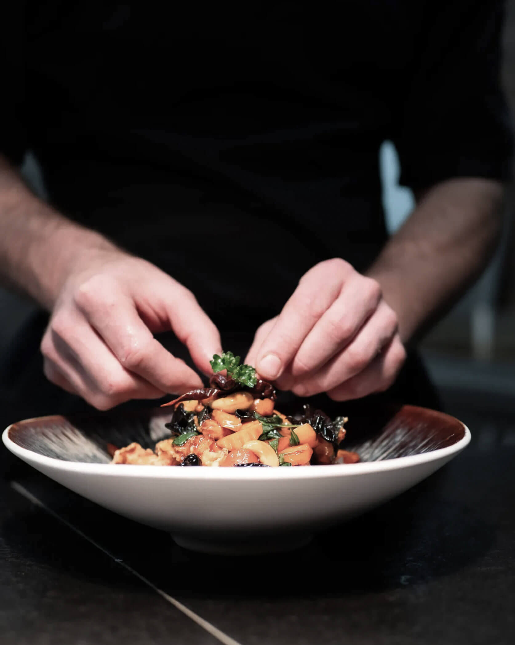 Honesty Bar & Dine Around Umami - Zubereitung Gericht auf einem Teller - Hofergut