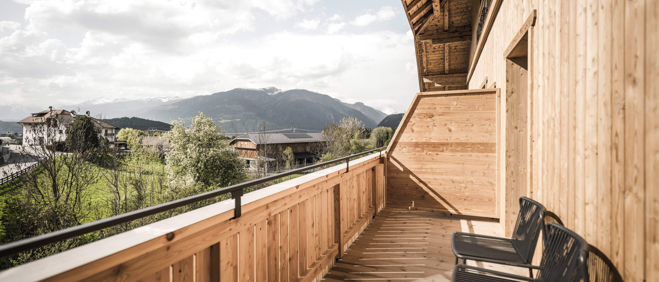 Suites & Apartments - Balkon aus Holz mit zwei Stühlen im Sommer - Hofergut